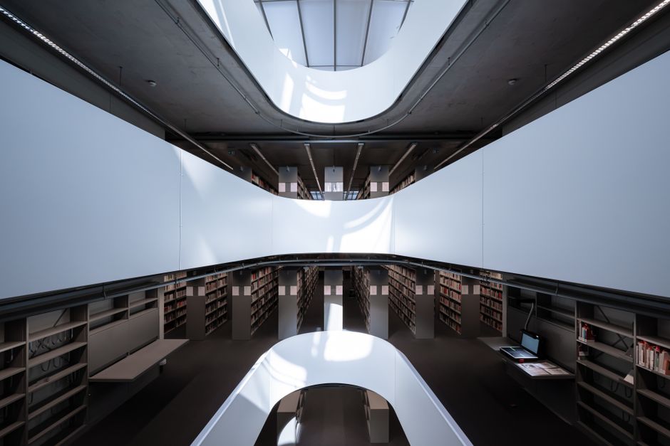 A sleek and contemporary library interior, showcasing modern architectural design and ample natural lighting.